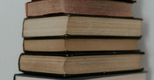 Stack of MBA textbooks on a clean white surface